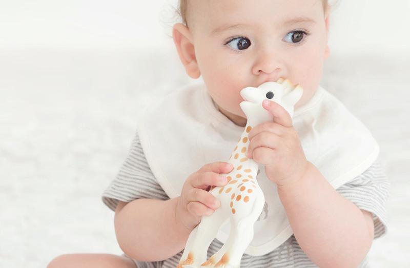 Vol Verwachting - Baby met slabbetje en bijt speelgoed giraffe