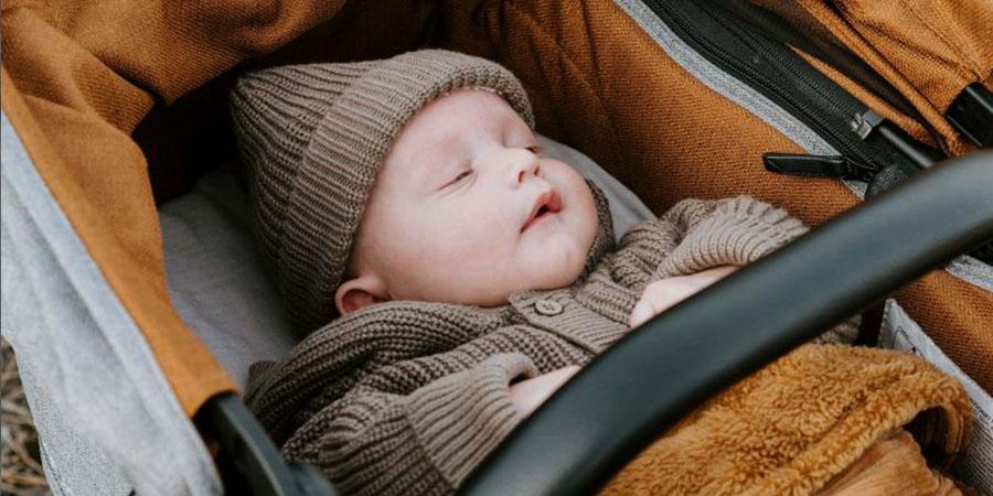 Vol Verwachting - Baby in buggy met mutsje op