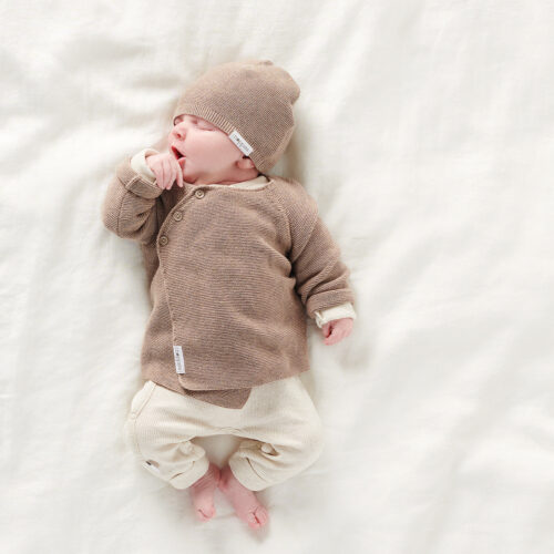 Vol Verwachting - Slapende baby met mutjes op een wit kleed