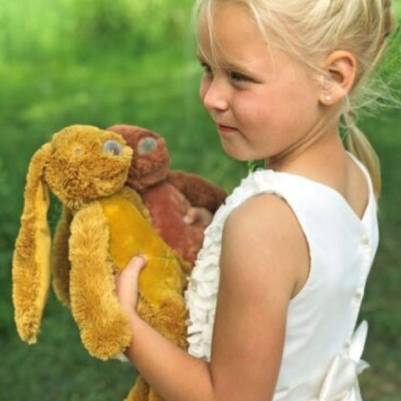Vol Verwachting - Meisje met twee verschillende knuffel konijnen buiten