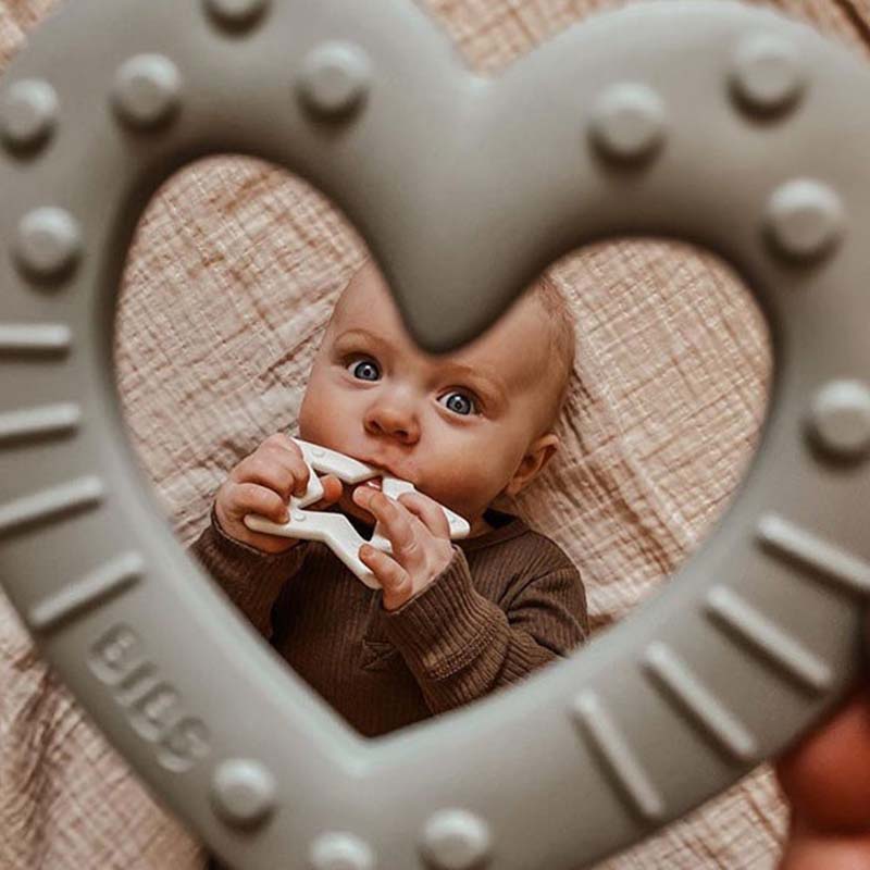 Vol Verwachting - Door een bijtring kijkend een baby zien die een bijtring in zijn mond heeft