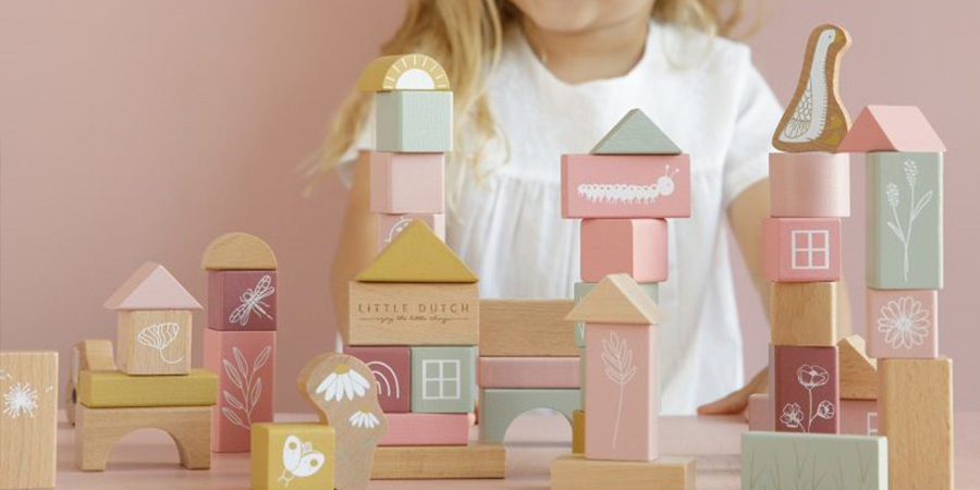 Vol Verwachting - Close-up van houten blokken speelgoed met kind op de achtergrond