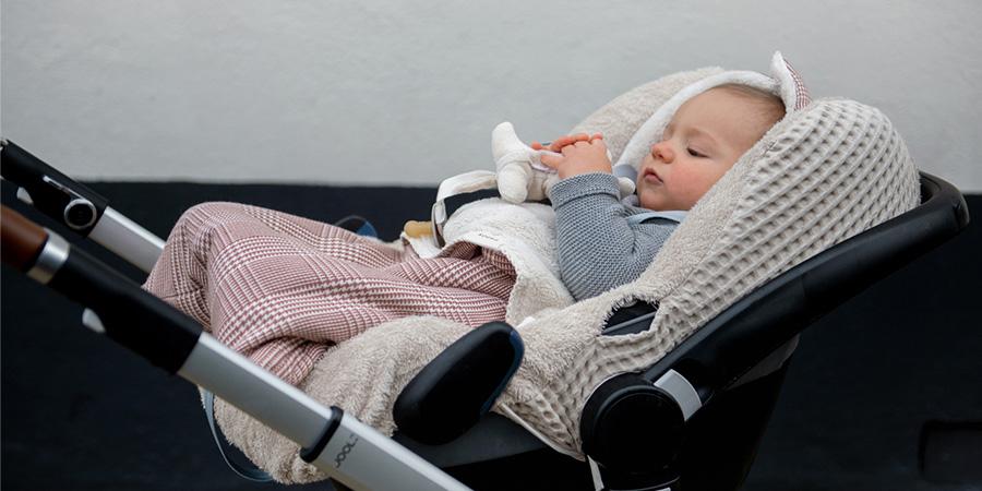 Vol Verwachting - Kind in buggy met een voetenzakje aan