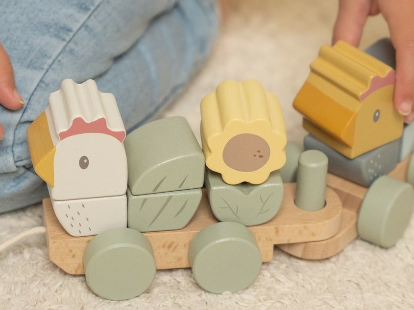 Vol verwachting - Kind dat speelt met houten speelgoed treintje